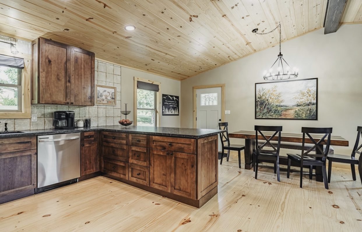 Beautiful kitchen with dark wood cabinets, light wood flooring and a kitchen table