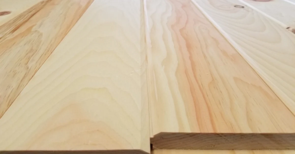 Close-up of unfinished wood plank boards showing natural grain patterns and a tongue-and-groove joint.
