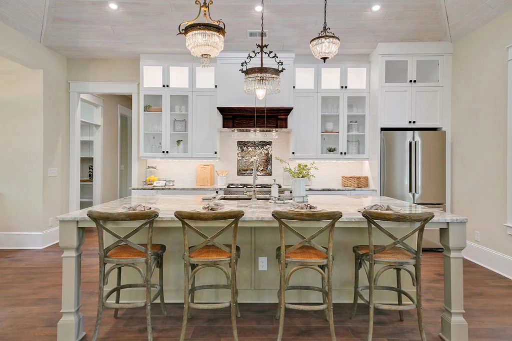 View of a kitchen with a large island with 4 stools