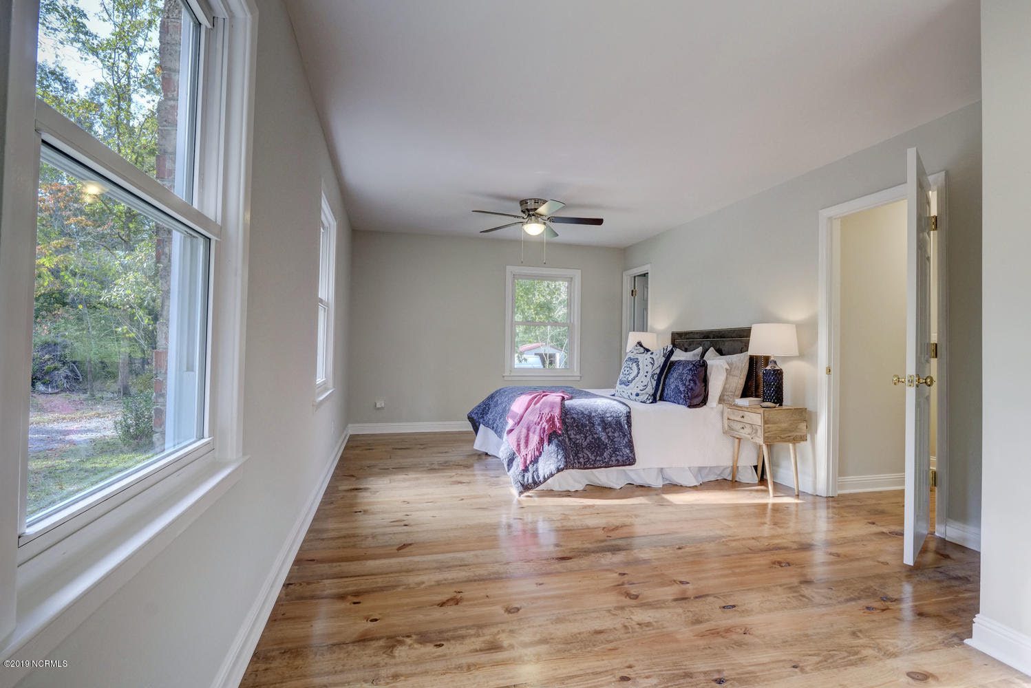 Large bedroom with a bed and wood floors