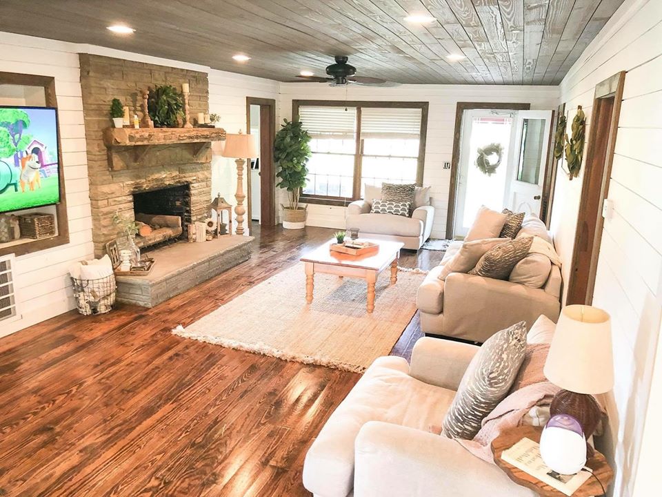 Large living room with wood floors and a floor to ceiling fireplace