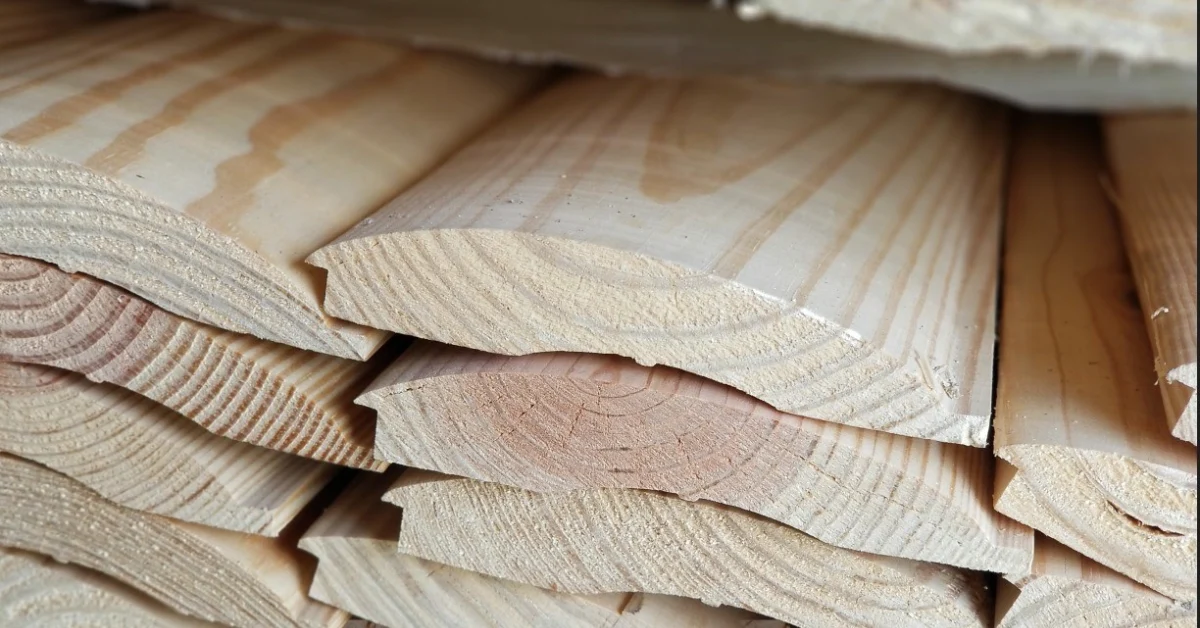 Close-up of stacked, milled wood boards showing visible end grain and growth rings.