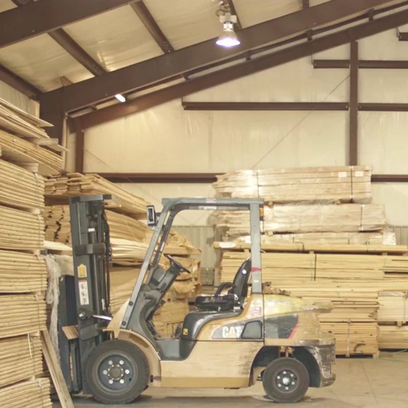 Stacks of Southern Yellow Pine in a warehouse with a forklift